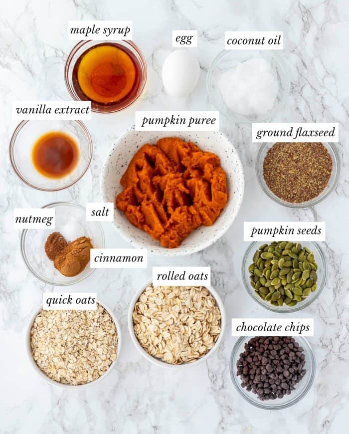 Ingredients for pumpkin breakfast cookies in glass bowls with labels.