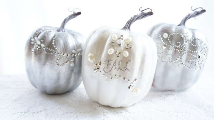 Three shiny pumpkins decorated with rhinestones and the word \"Fall\"