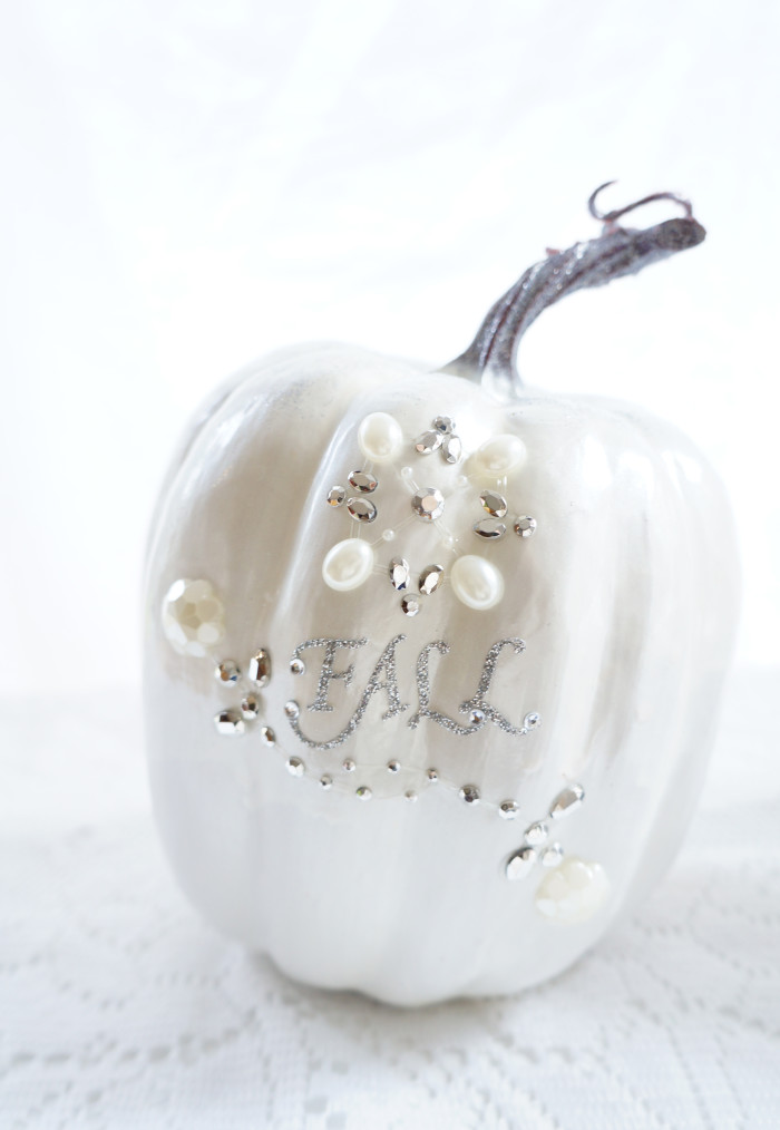 Shiny, white pumpkin with shiny and pearl embellishments with the work \"Fall\" in sliver glitter