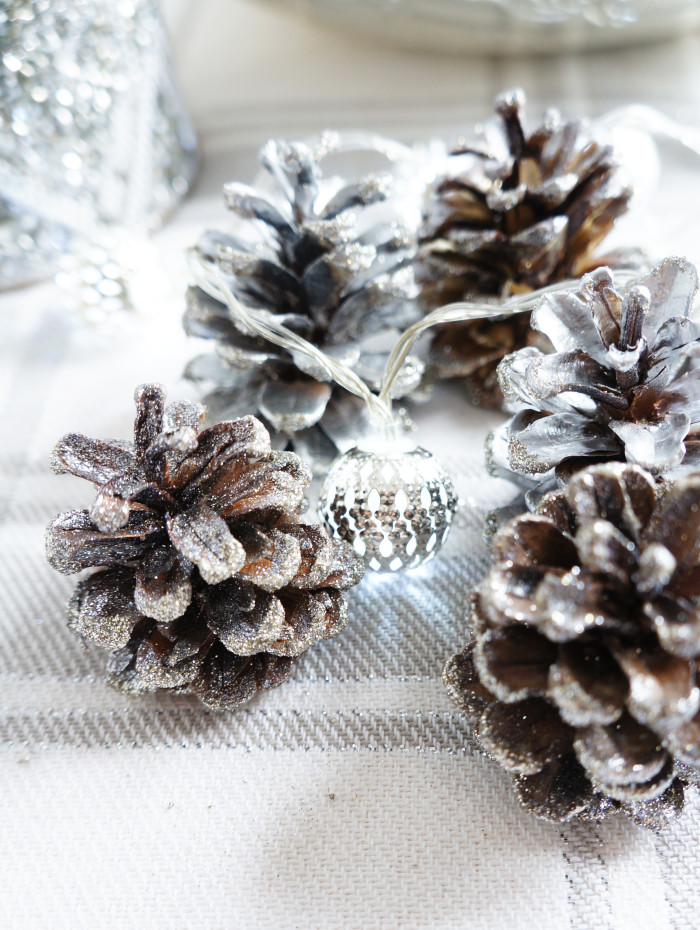 Sparkly Pinecones adorned with an ornament-shaped Christmas light