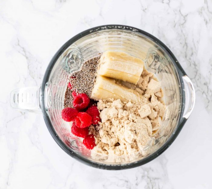 ingredients in blender for raspberry banana smoothie