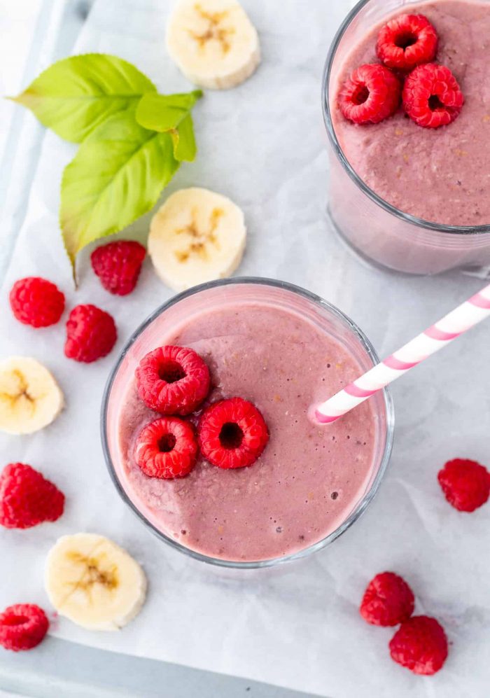 raspberries in a smoothie with a straw