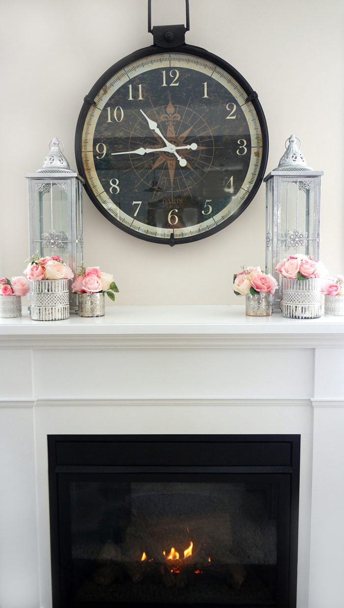 Pink Spring rose bouquets in silver votives with candles on fireplace mantel