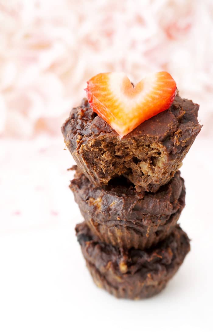 Stack of 4-Ingredient Flourless Chocolate Brownie Cups with a bite missing, topped with a heart-shaped strawberry slice