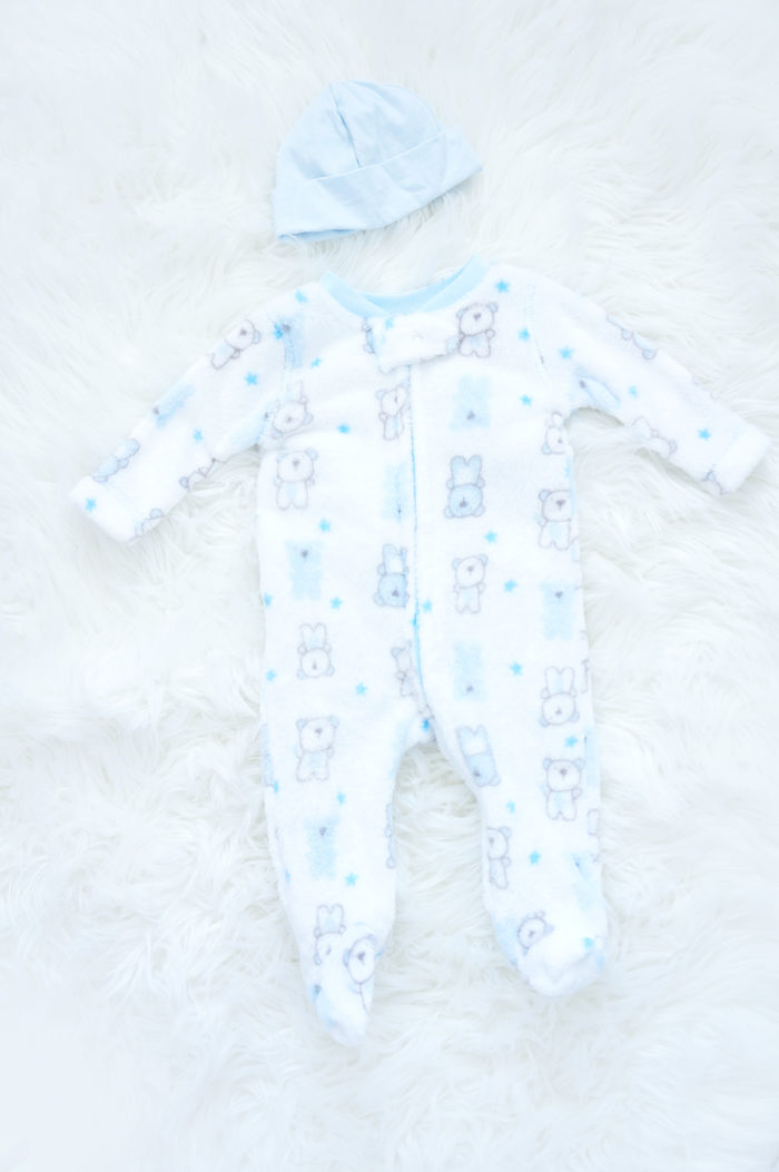 Long-sleeve onesies in a bear print and a blue infant hat
