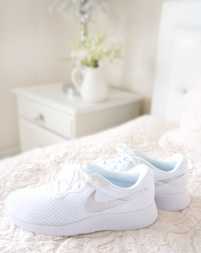 White Nike shoes on a bed