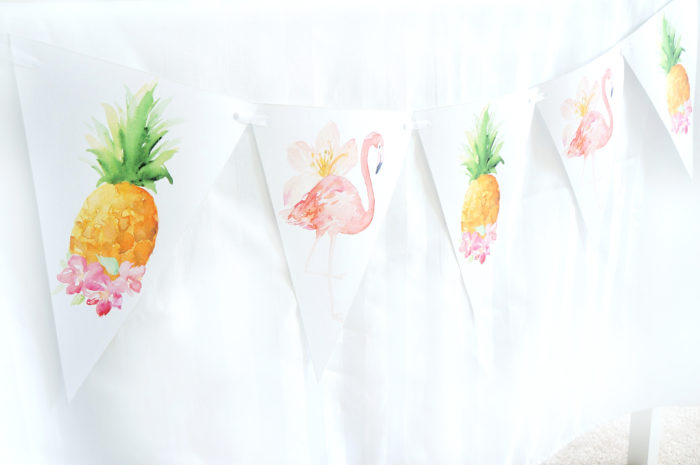 Banner with flamingos and pineapples on a white tablecloth