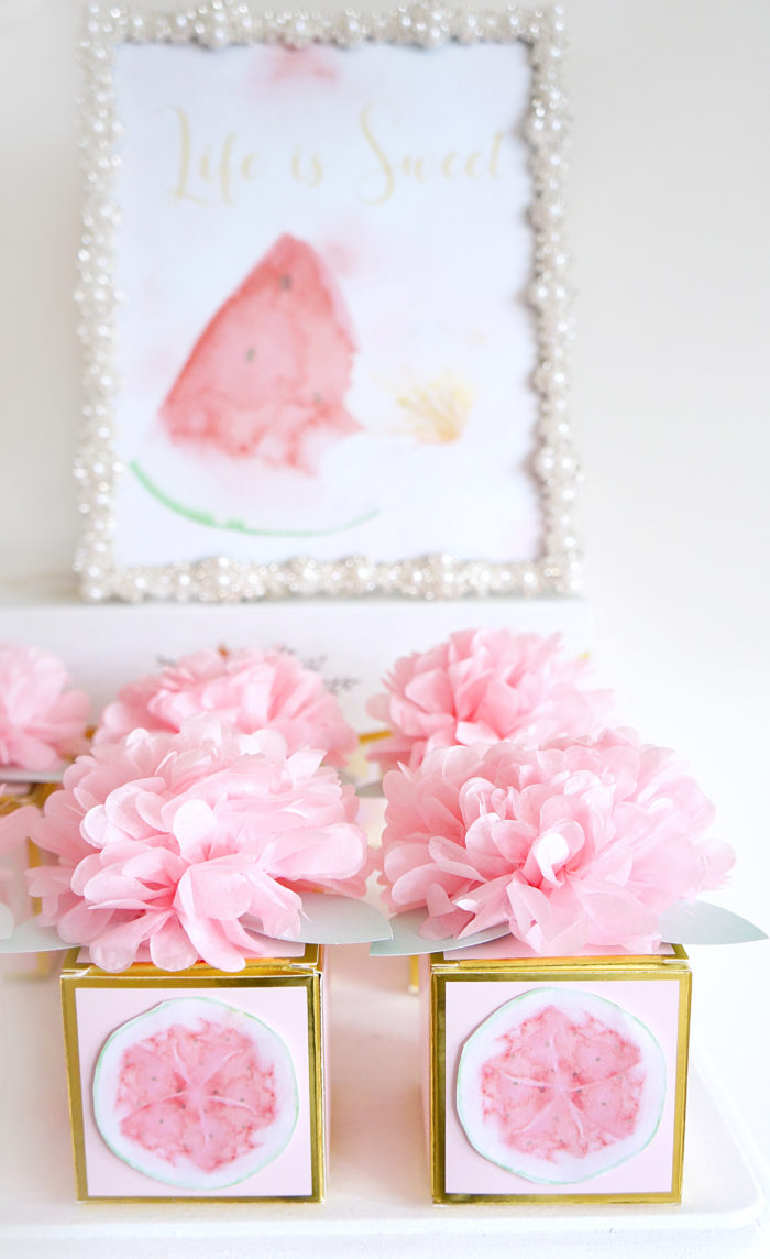 Golden boxes with pictures of watermelon topped with pink flowers