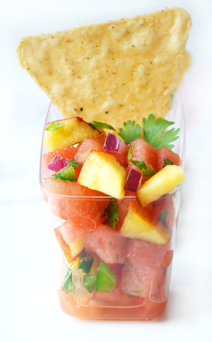 Closeup of a small bowl of Watermelon Peach Salsa with a tortilla chip sticking out