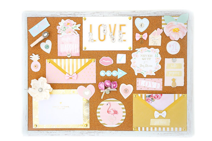 Cork board covered in pastel papers and decorations