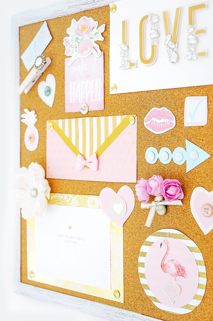 Diagonal view of a cork board full of pastel papers and decorations