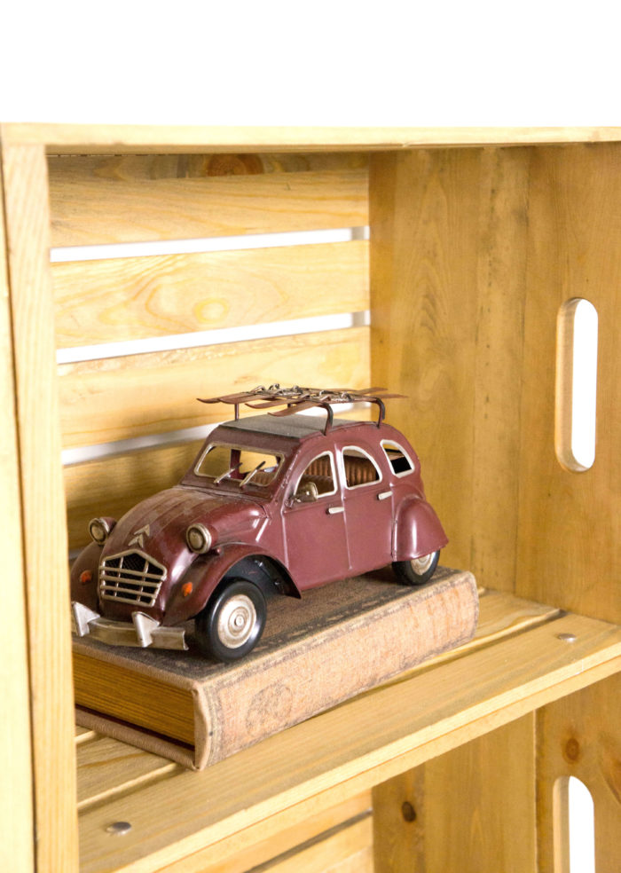 Old fashioned car on a book in a wooden crate