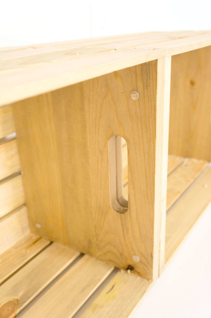 Closeup of wooden crates attached by wood-colored screws