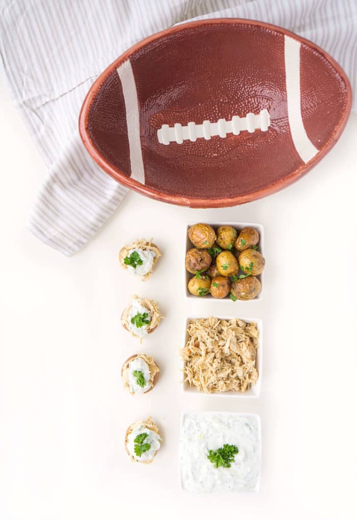 Overhead shot of Stuffed Chicken Gyros Touchdown Taters next to the ingredients and a football-style bowl