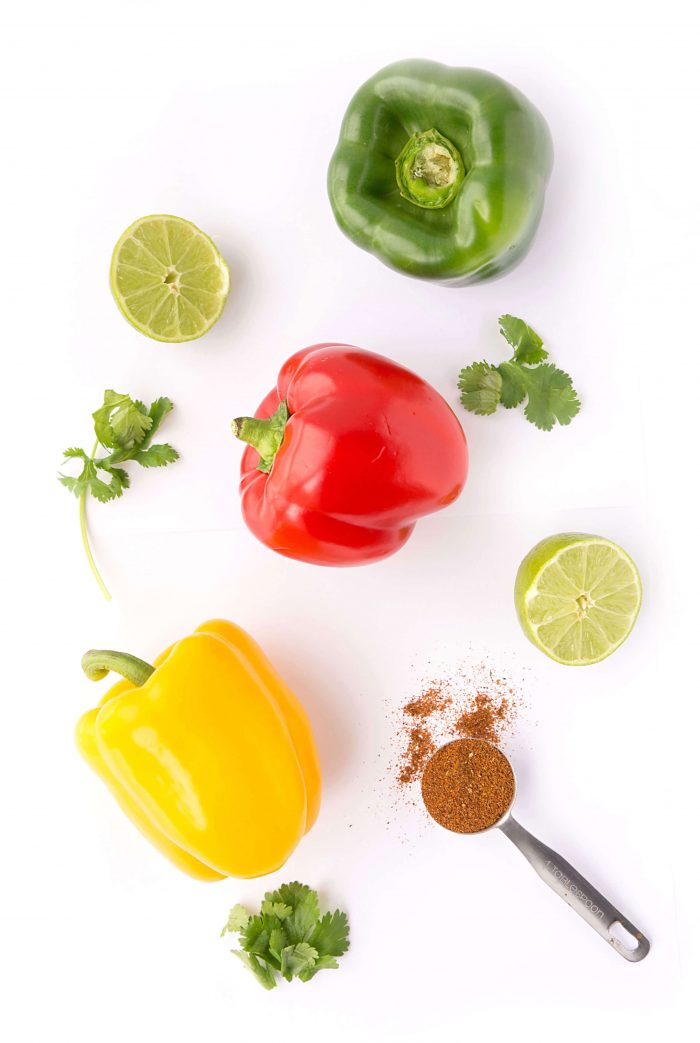 Fajita ingredients including colorful bell peppers, cilantro, lime, and seasoning