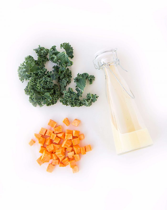 Kale, diced sweet potatoes, and a jar of creamy roasted garlic dressing