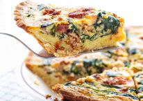 slice of low carb spinach bacon quiche on spatula