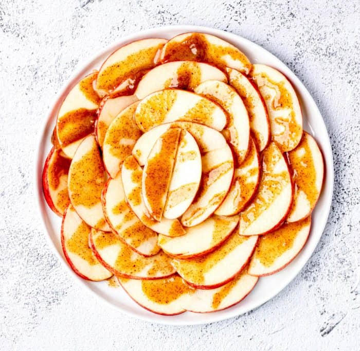 apple slices with caramel drizzle on white plate