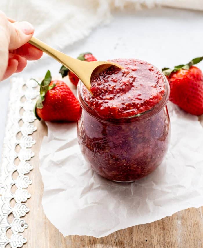 A wooden spoon in a jar of chia seed jam.