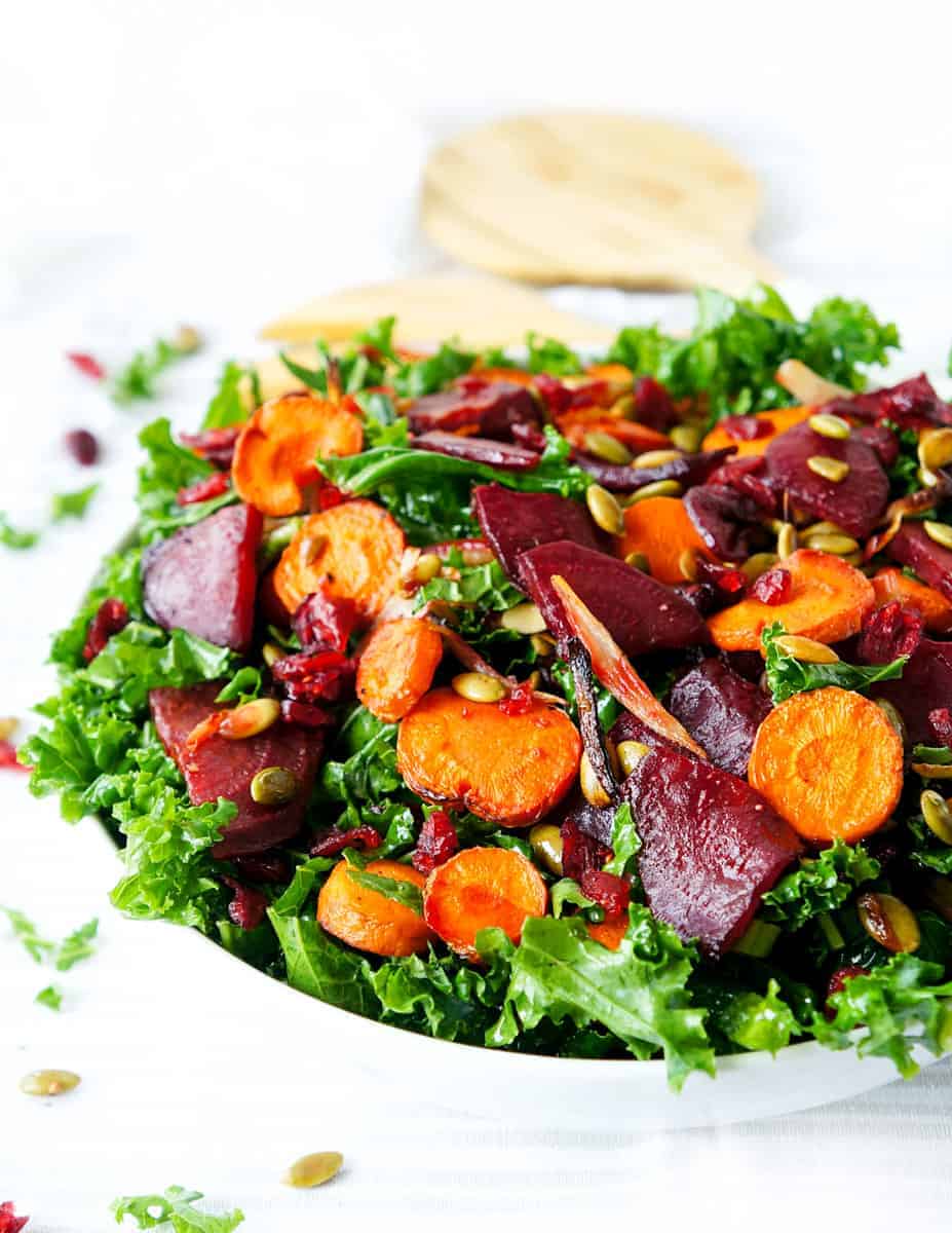 Beet, carrot and kale salad served in a large white bowl.