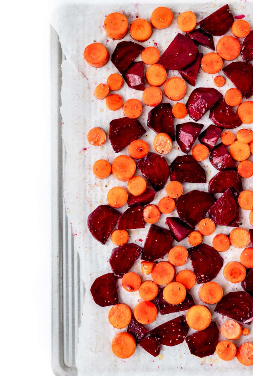 Roasted beets and carrots on a baking sheet.
