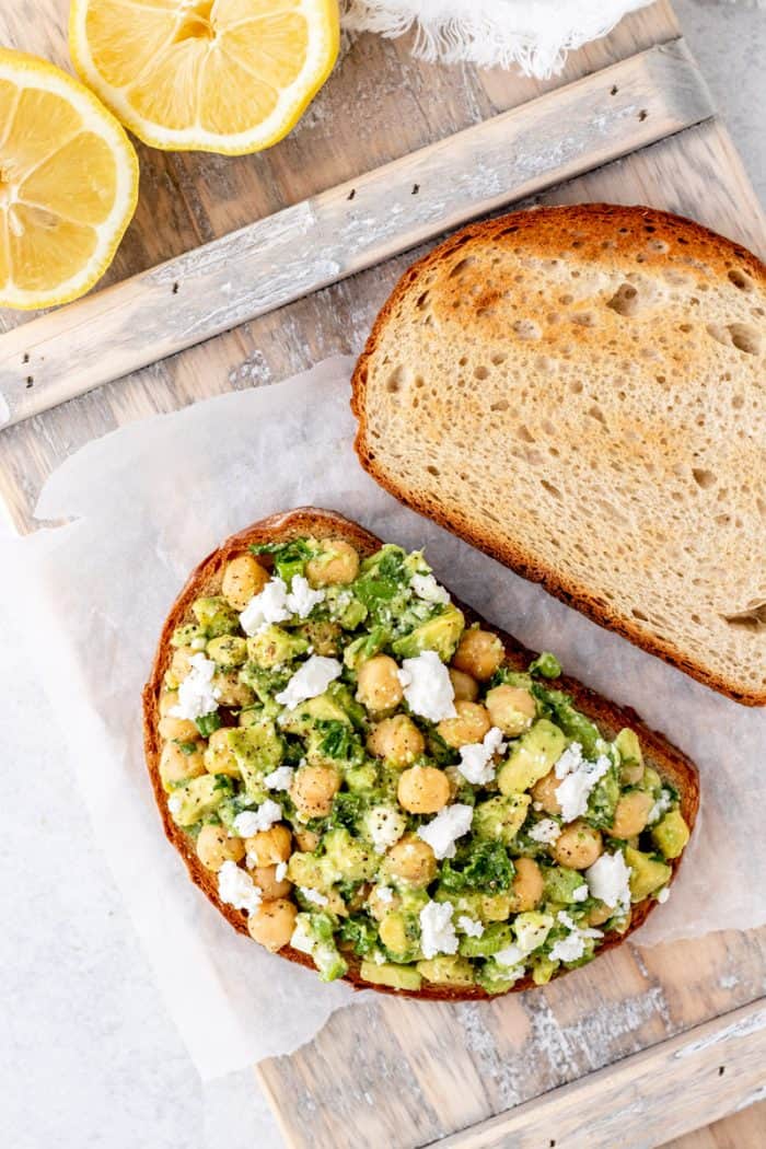 Chickpea salad placed on top of a slice of bread.