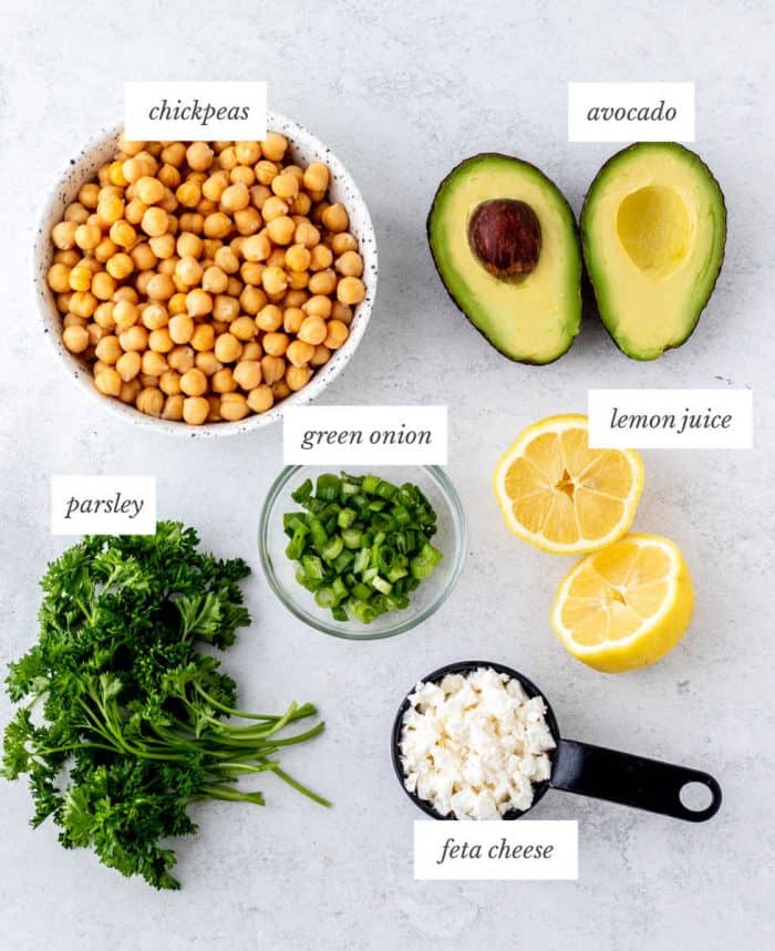 ingredients required for simple chickpea salad on grey background with labels