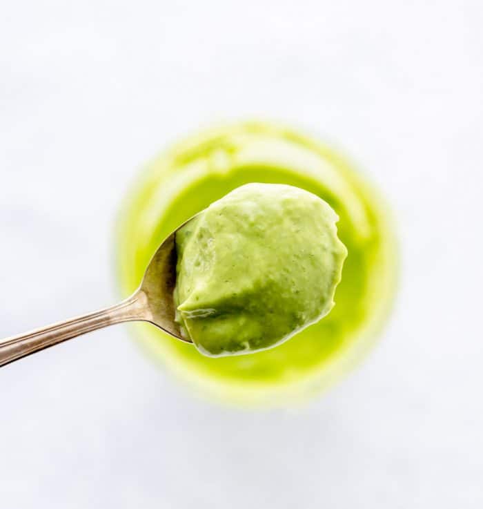 Some of the green goddess dressing on a spoon.