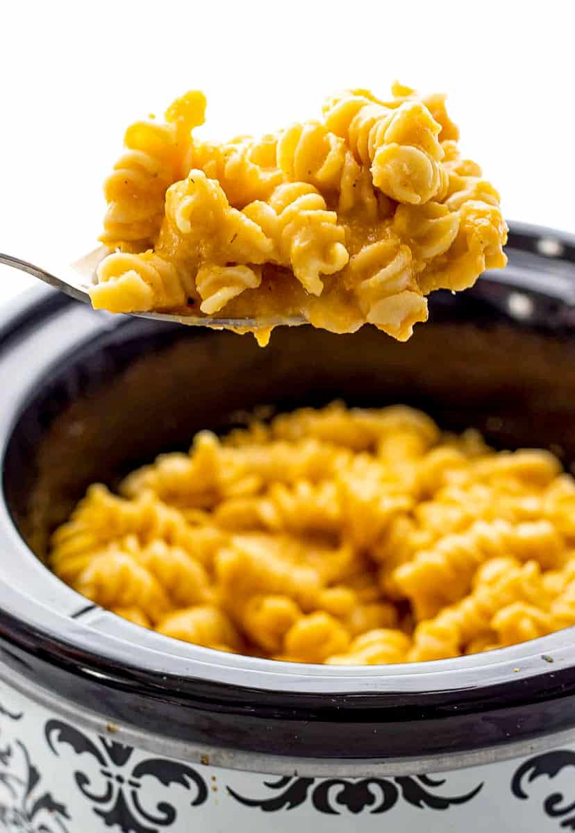 Scooping butternut squash mac and cheese out of crockpot.