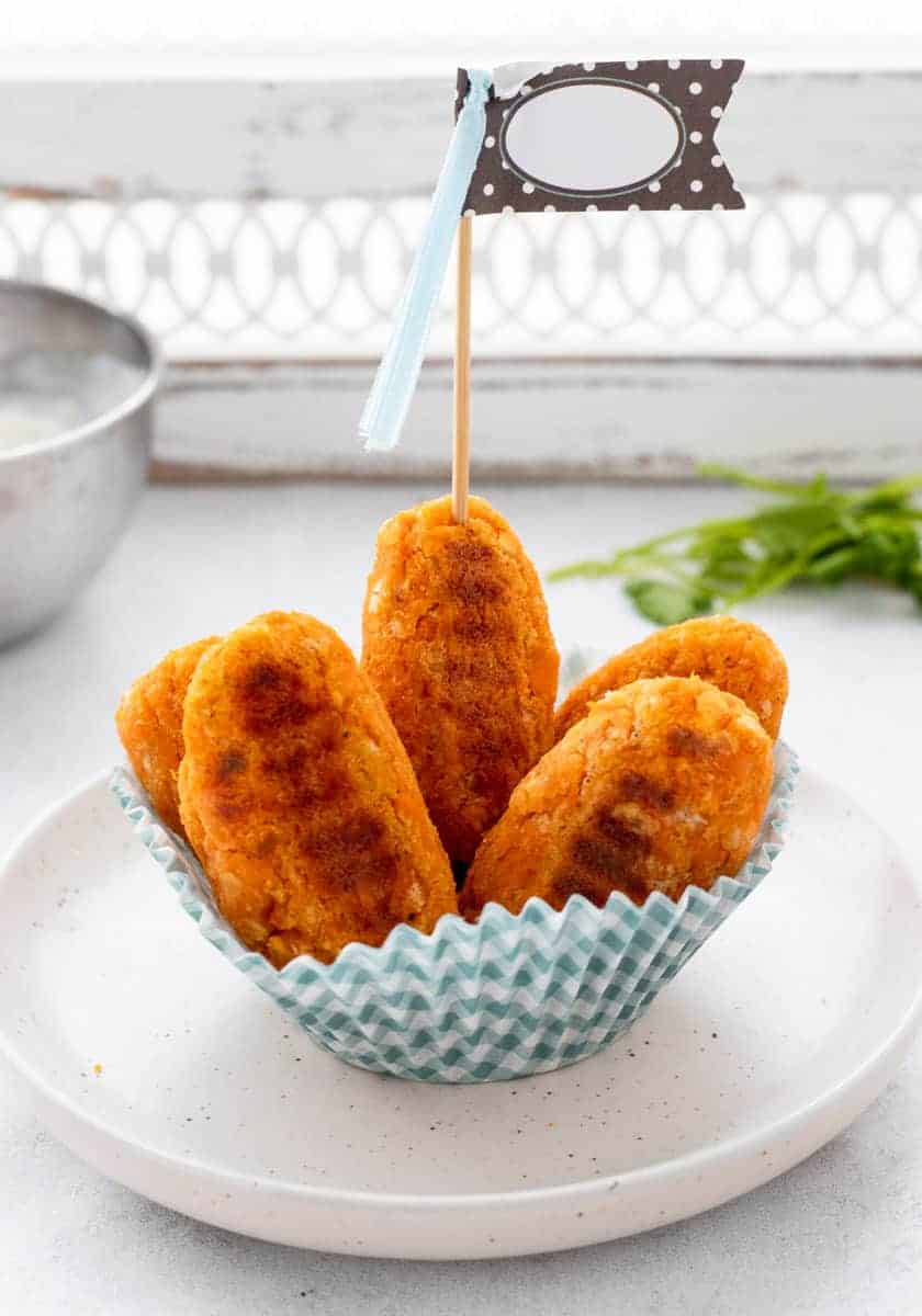The tots served in a muffin cup with a skewer through one.