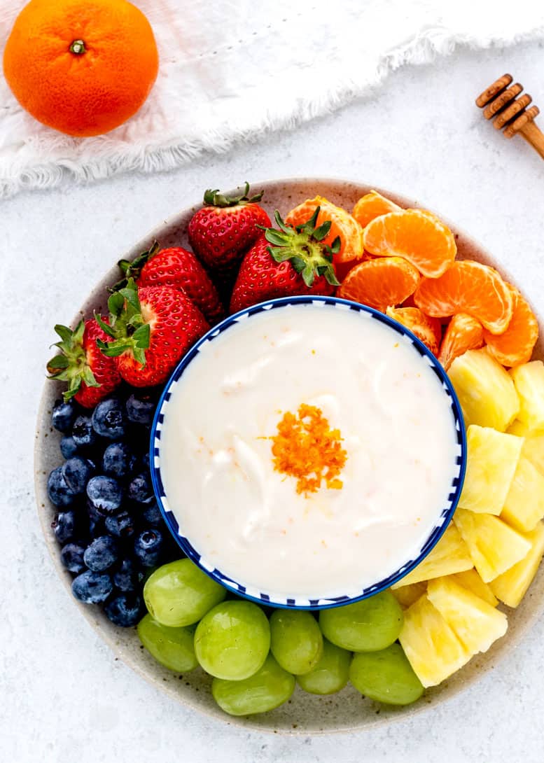 A yogurt dip served in the middle of a fruit platter.