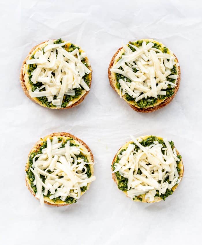 Muffins topped with shredded cheese.