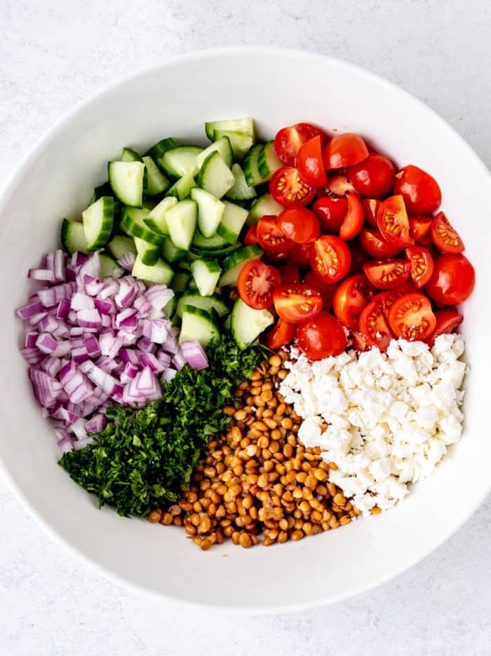 The salad ingredients added to a bowl.