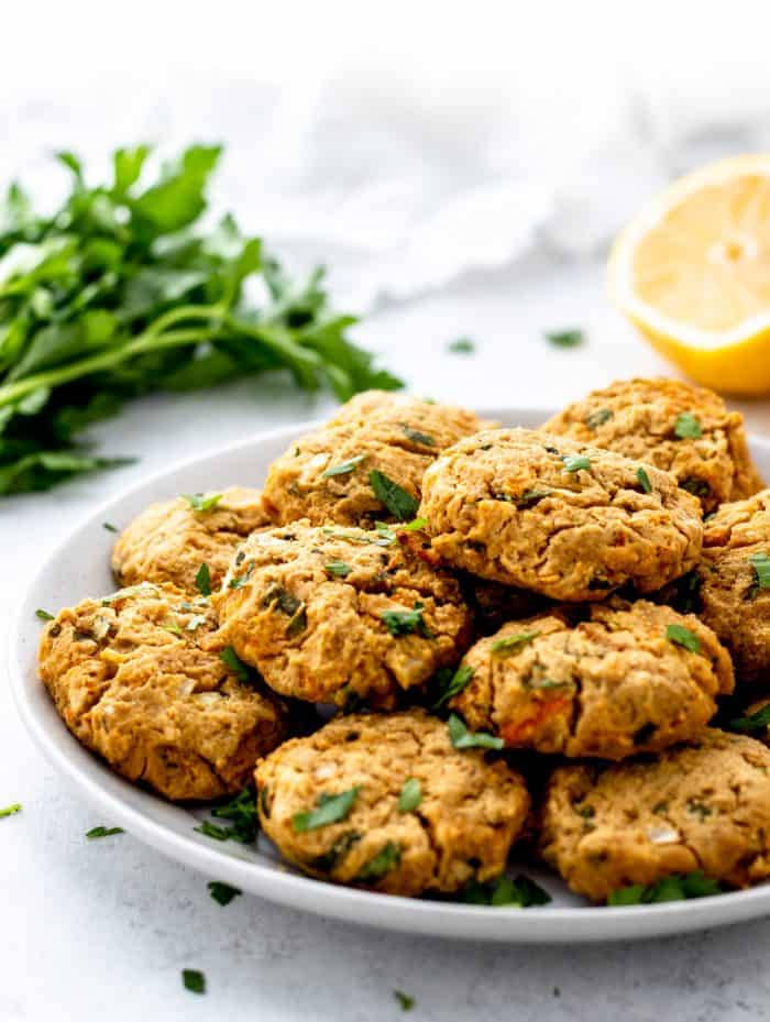 plate of baked falafels next to lemon and parsley