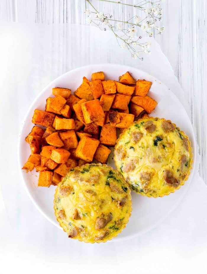 overhead shot of two egg muffins on a plate with diced sweet potato