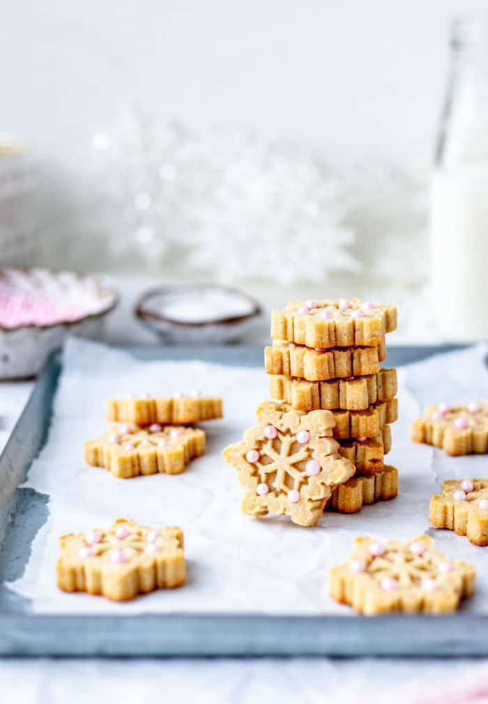 Snowflake almond flour cookies stacked on top of each other.