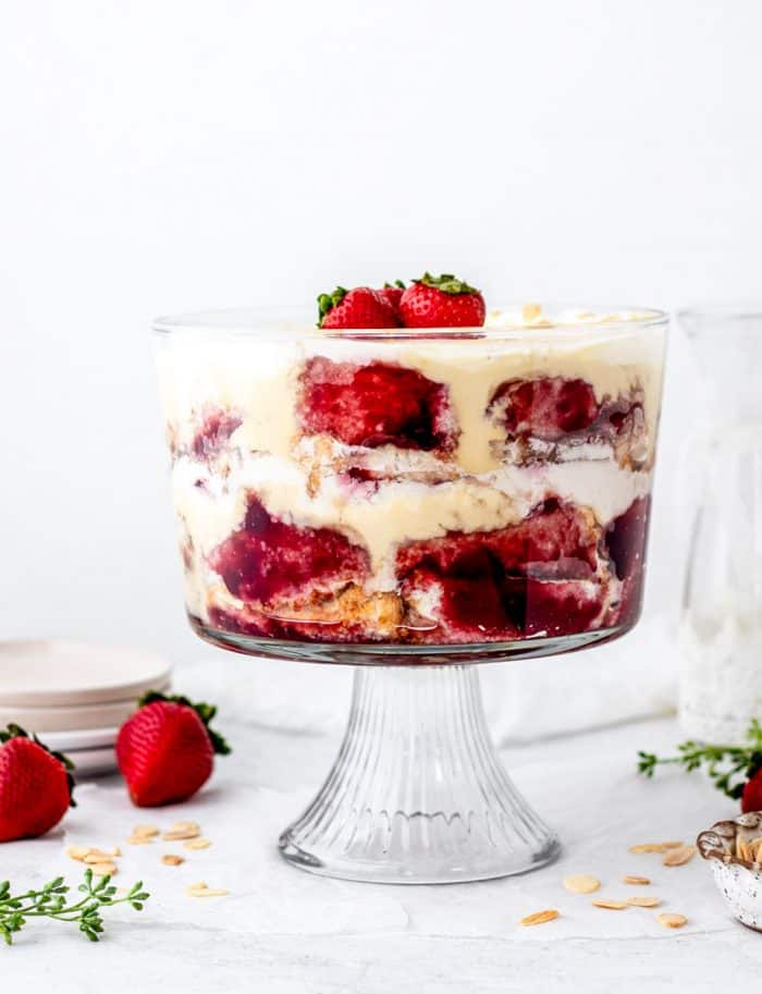 Christmas trifle layered in a clear glass bowl topped with strawberries