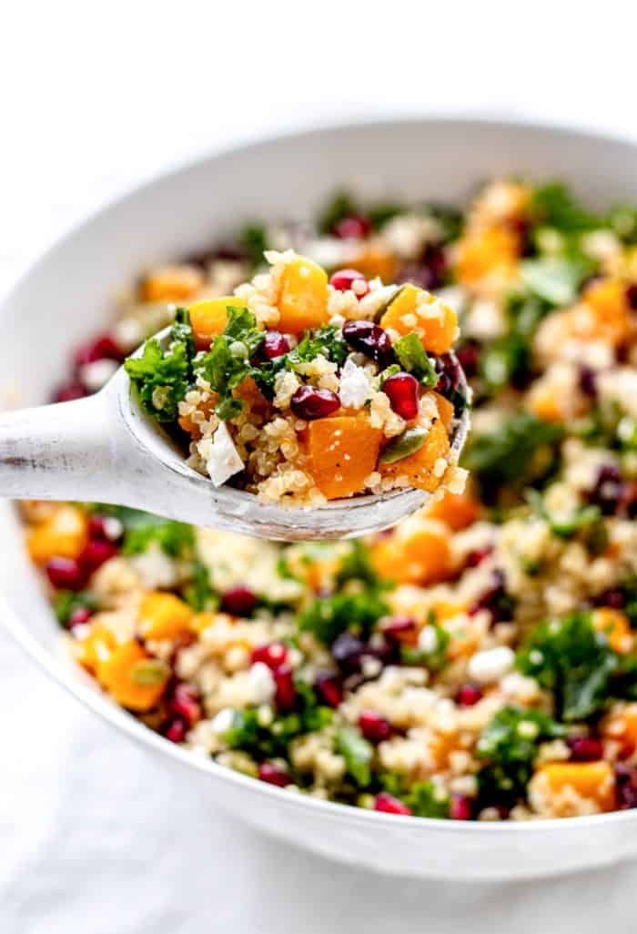 quinoa salad being held up on a rustic white spoon