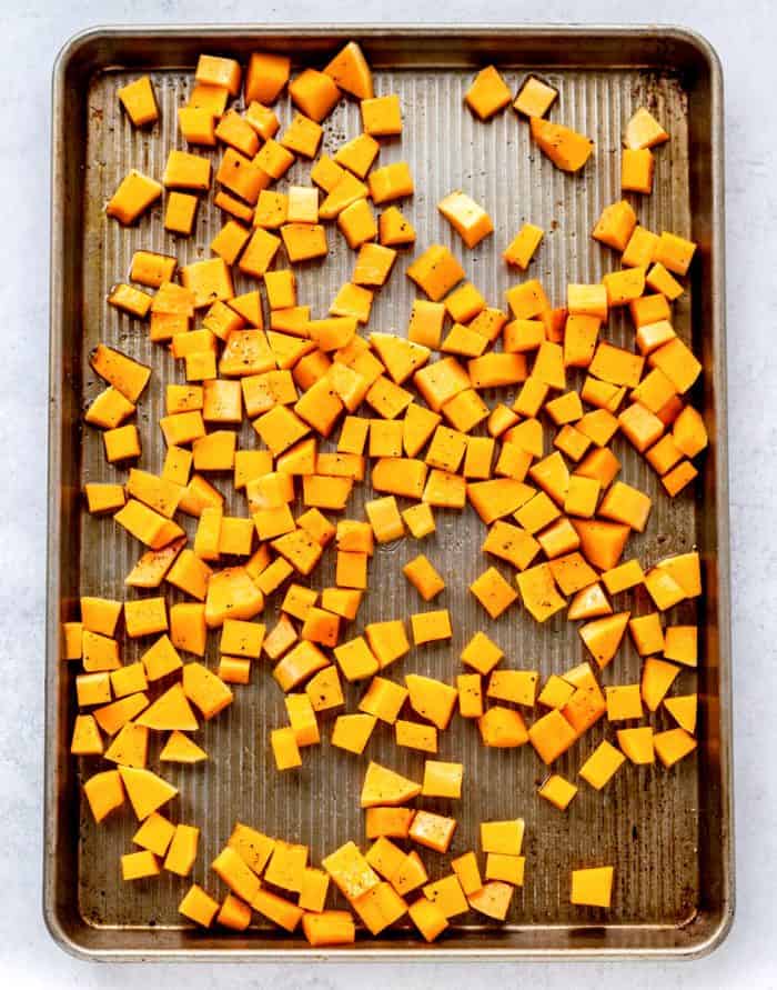 the cubed butternut squash on a baking sheet ready to be baked
