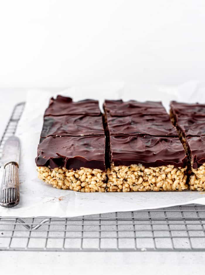 The chocolate rice crispy treats cut into squares on a rack.