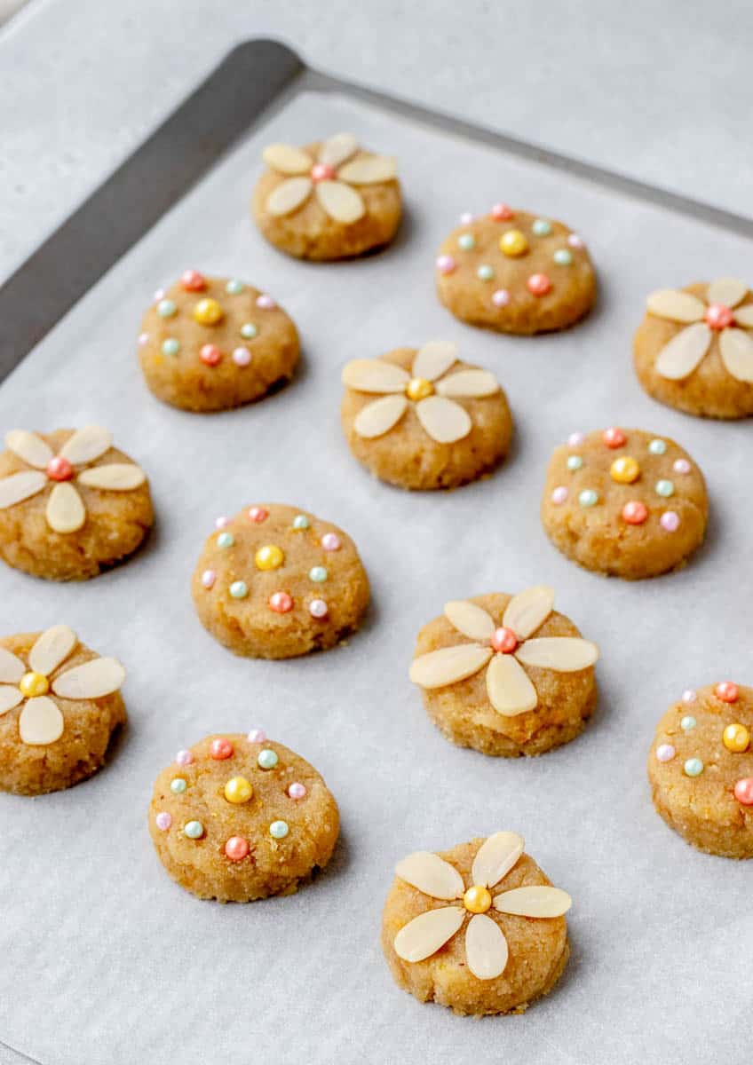 Decorated lemon flower cookies on a baking sheet.