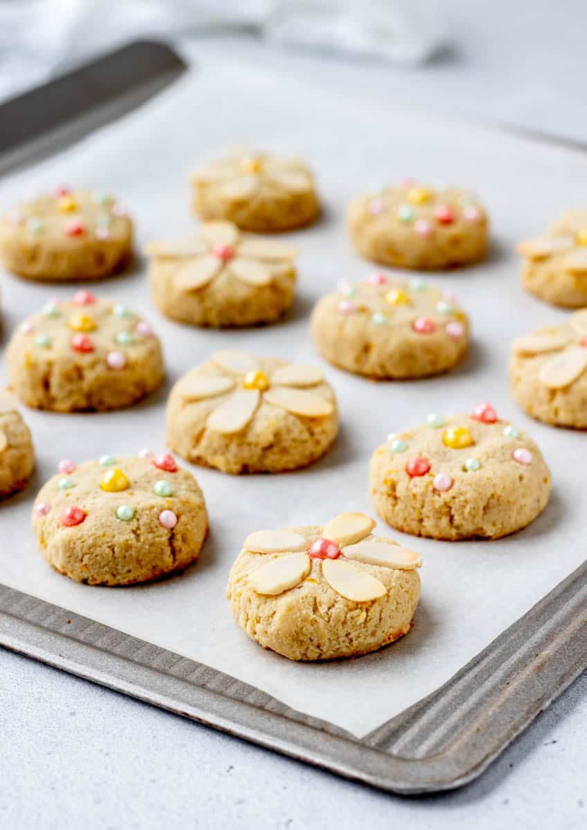 Lemon almond flour cookies decorated with sliced almonds and sprinkles.