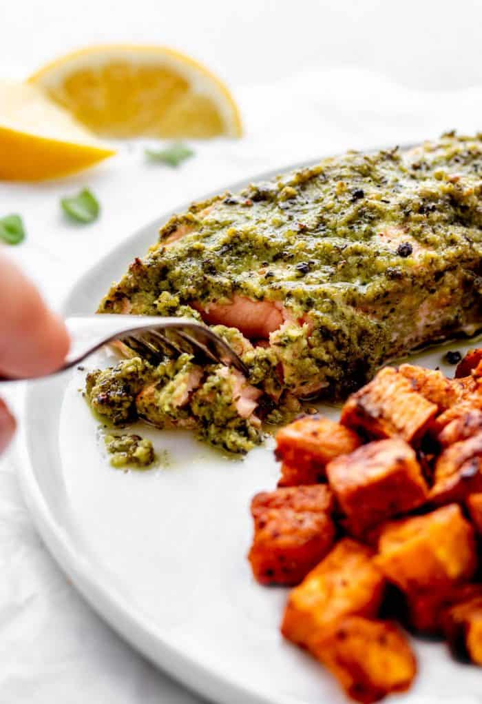 Baked pesto salmon being eaten with a fork.