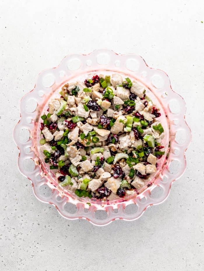 Cranberry walnut chicken salad in a bowl tossed in the dressing.