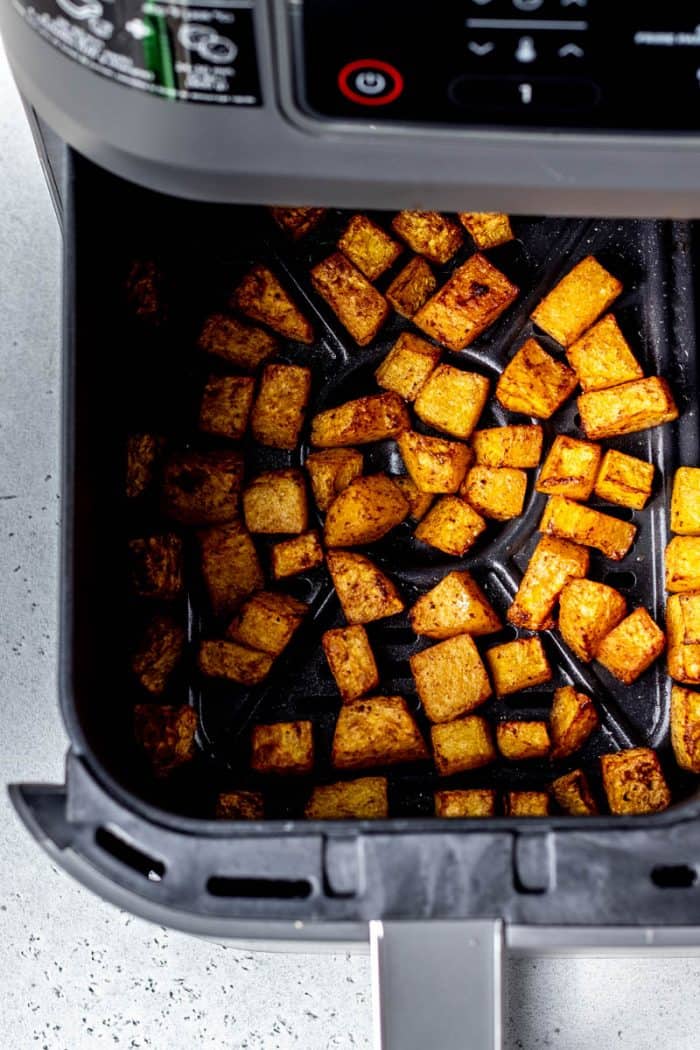 Overhead image of roasted butternut squash cubes in the air fryer.