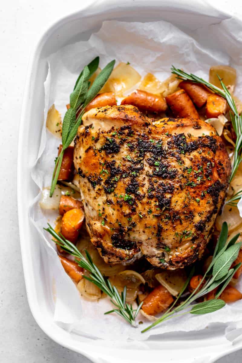 A cooked slow cooker turkey roast with vegetables after being broiled.