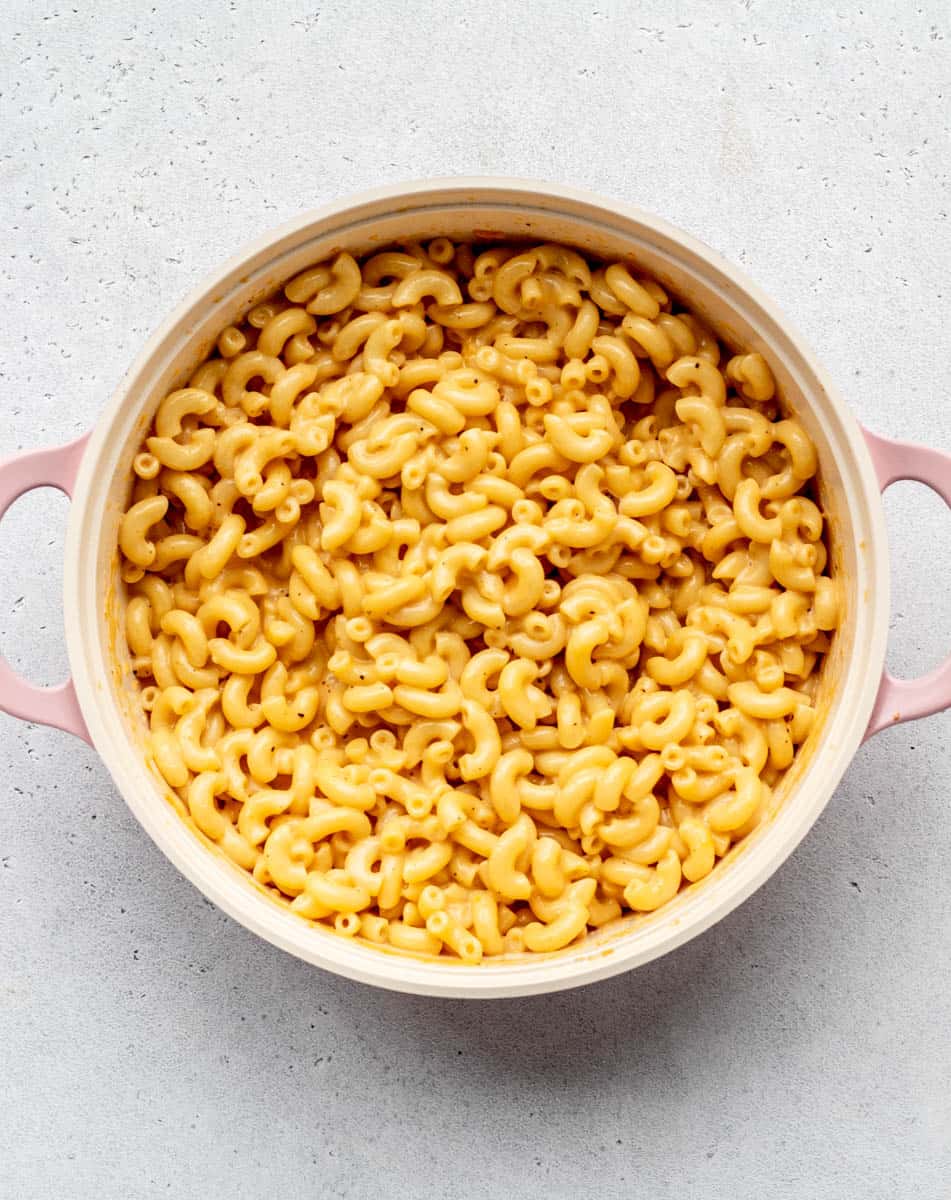A top down view of a pot of 5 ingredient mac and cheese without flour, sprinkled with salt and pepper.