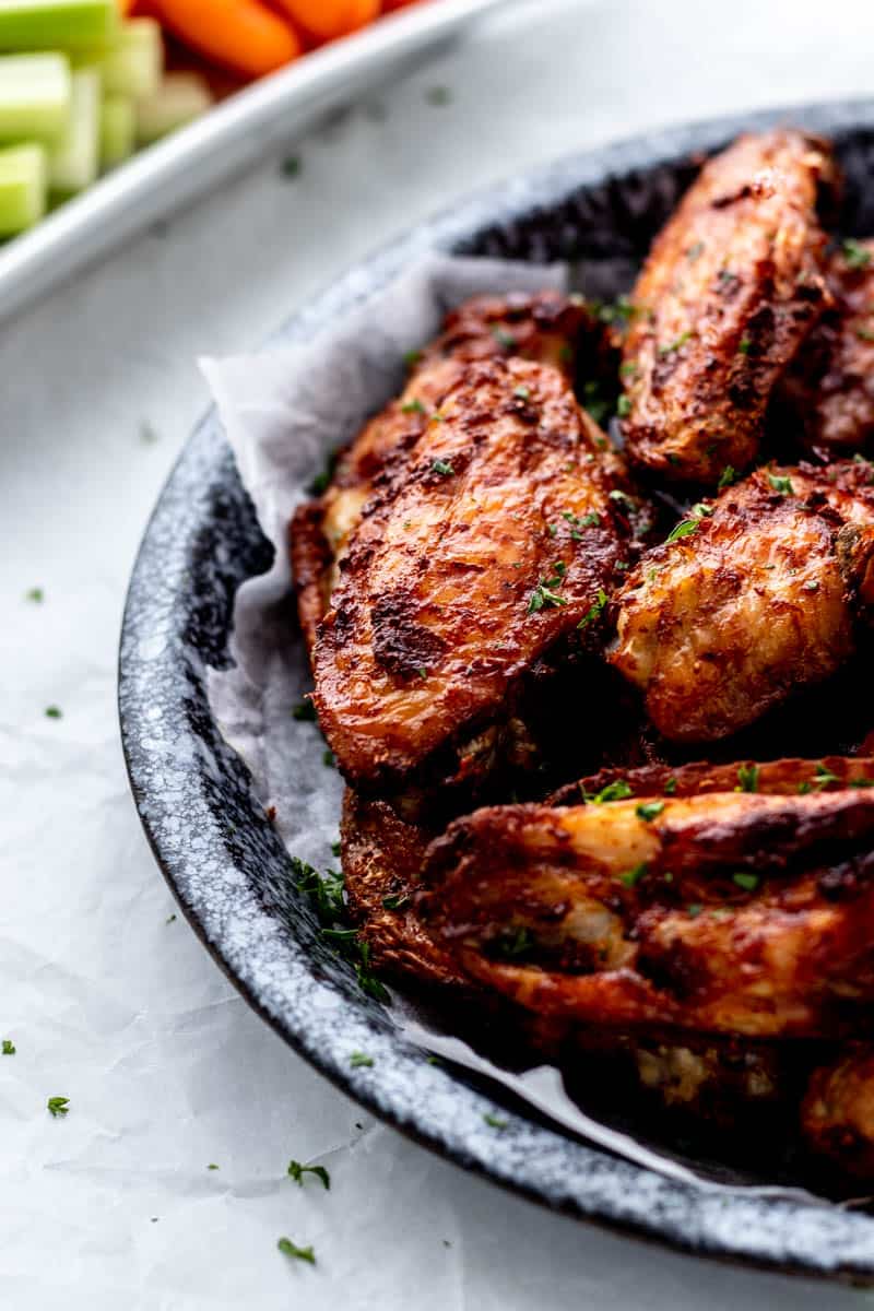 Close up image of a bowl of baking powder air fryer chicken wings.