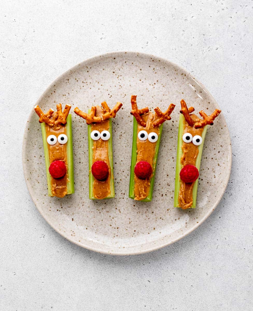Four Rudolf celery sticks on a speckled plate.