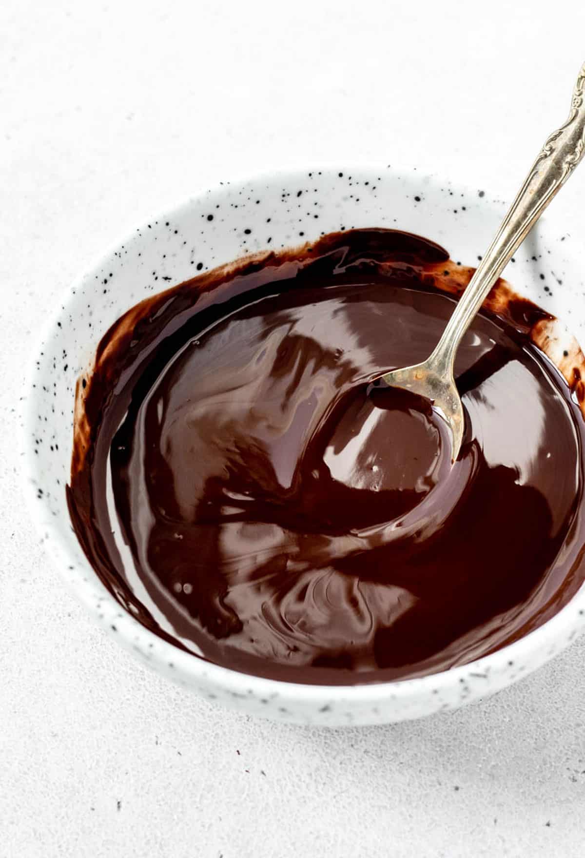 A bowl of melted dark chocolate and coconut oil.